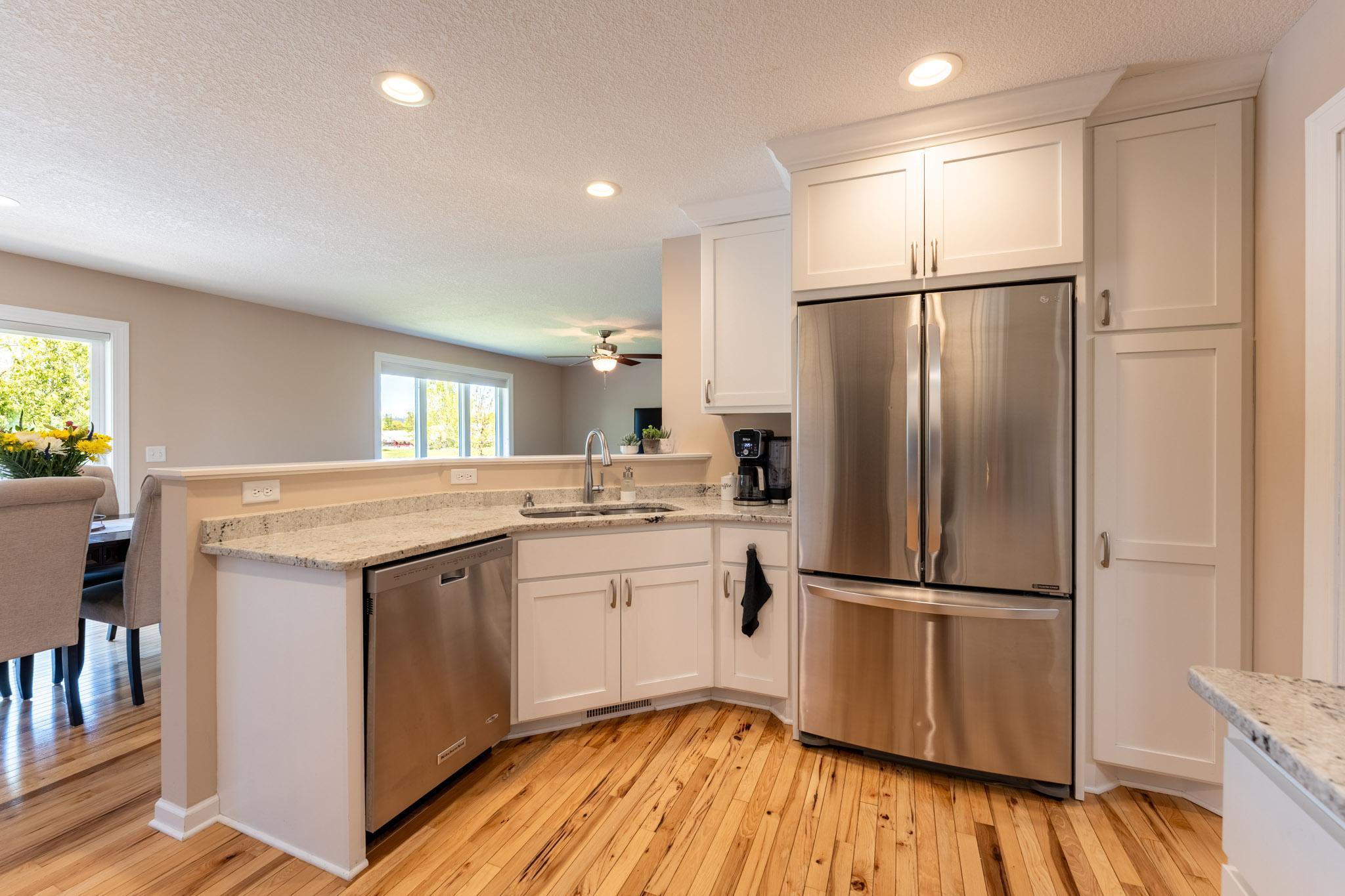 French door refrigerator with lower freezer, with pantry cabinet next to it.