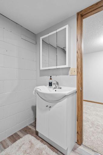 Convenient basement 1/2 bathroom with new floor and fixtures.