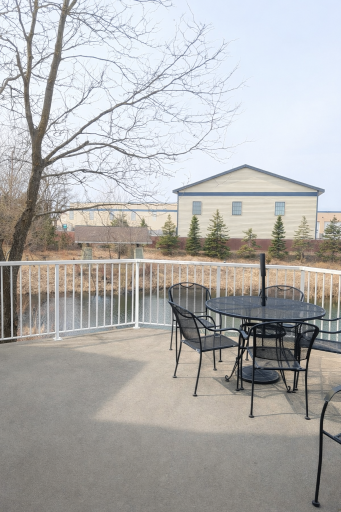 Community patio with serene pond views, gazebo access, and a nearby walking trail.