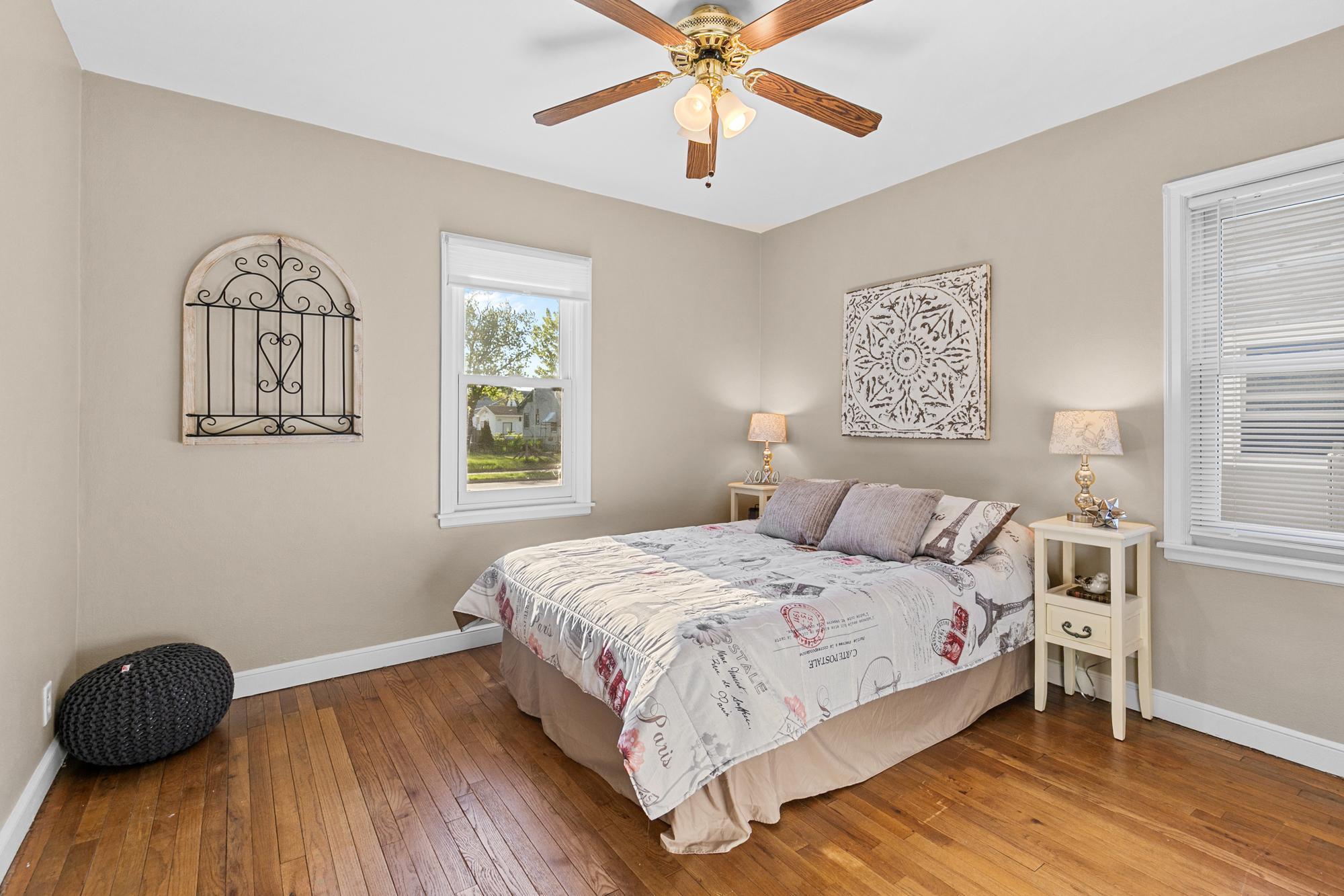 Main level bedroom #1 with hardwood floors, fresh paint and ceiling fan.