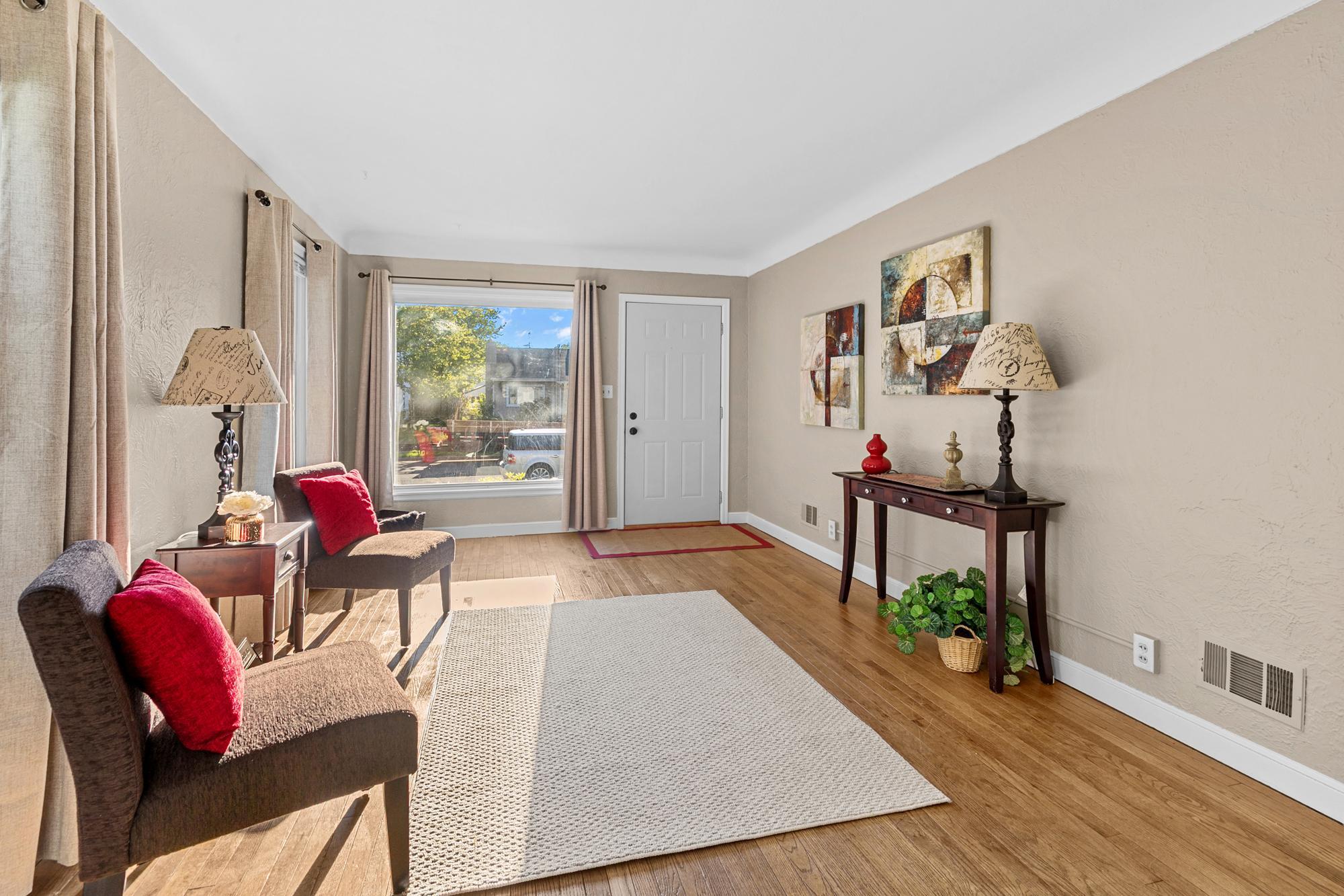 The living room has hardwood floors, fresh paint and new draperies.