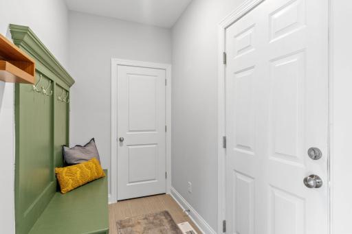 Entrance from the insulated, 3-car garage into the mudroom and walk-in coat closet.