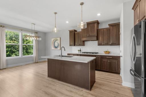 The kitchen boasts extensive cabinetry, stainless steel appliances, center island, and walk-in pantry.