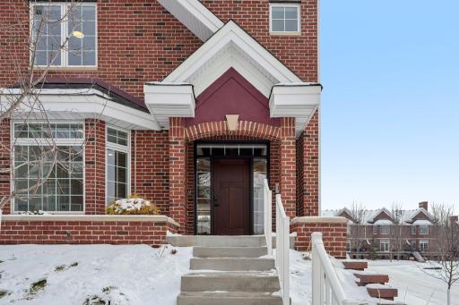 Welcoming covered front entry framed by classic brick detailing, offering a warm and inviting arrival.