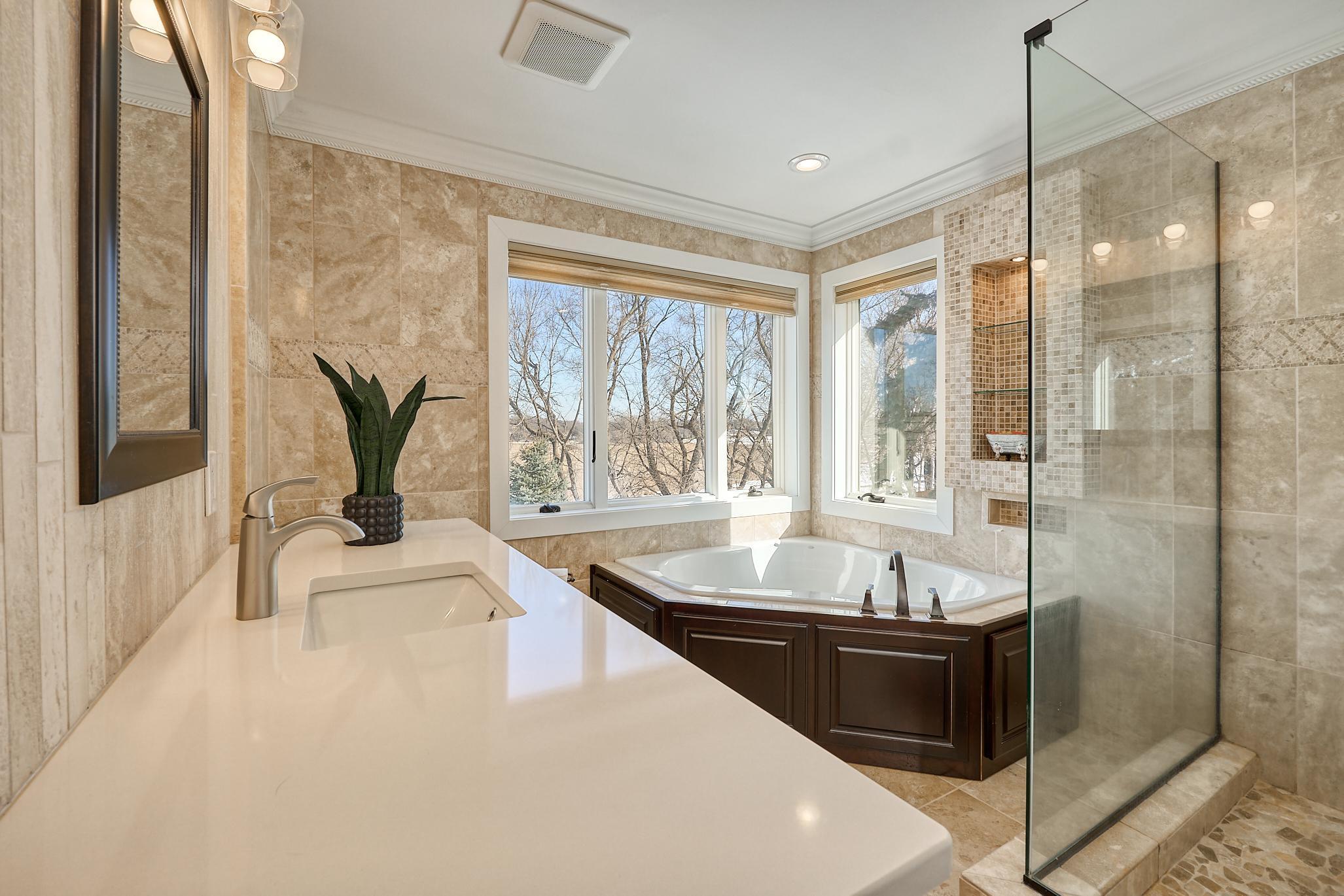 Primary Bath. Step-in Glass Shower, Dual Vanities, Deep Soaking Tub with a Treetop View