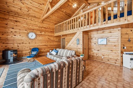 Spacious family room with vaulted ceilings, a charming knotty pine interior, and tasteful lake-inspired dÃ©cor.
