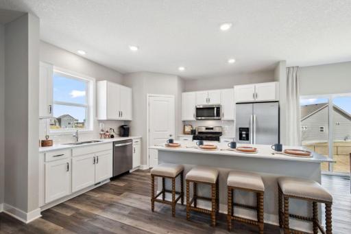 Open and spacious kitchen with stainless steel appliances, kitchen window and quartz countertops.