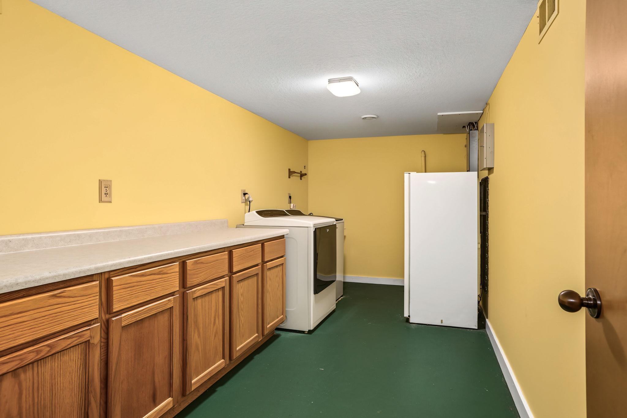Fully finished laundry room with folding counter. Lower level freezer will stay for new owner.