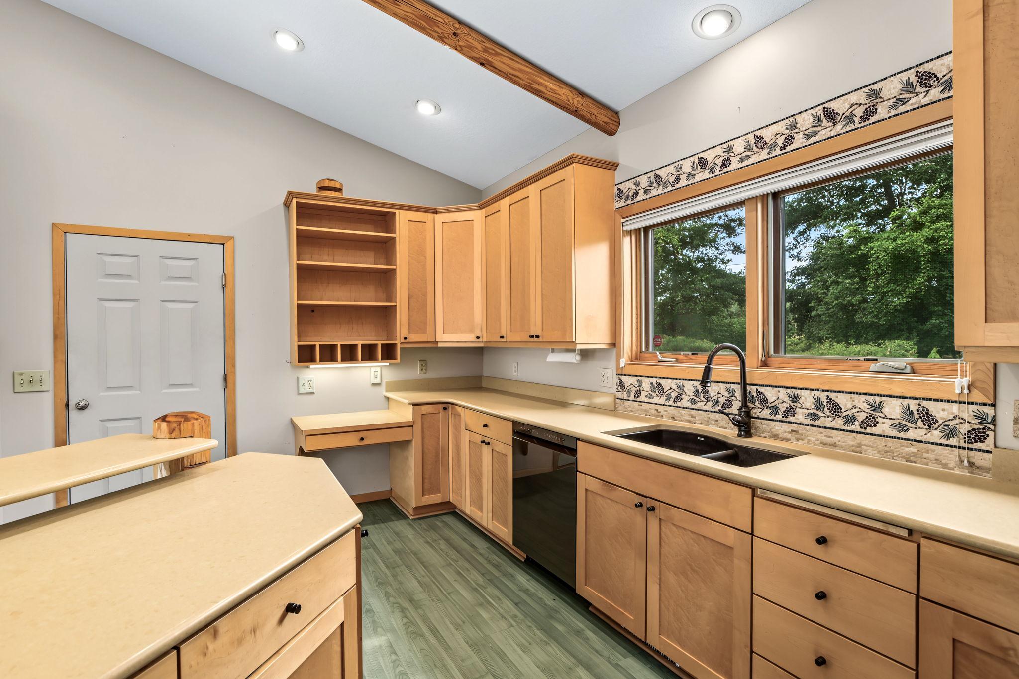 Decorative wood beams accent the vaulted ceiling, while the built-in desk with Silestone countertop creates the perfect workspace, homework station or convenient drop zone.
