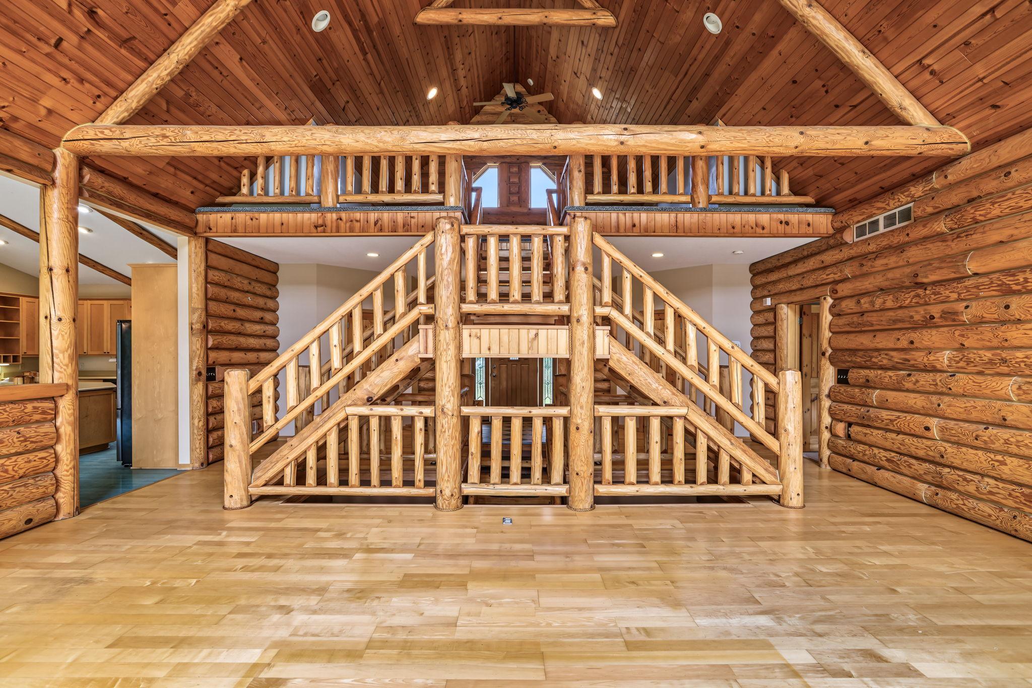 Exceptional craftsmanship is on display throughout the great room - a dramatic open log staircase, soaring wood ceilings, exposed beams, and an open loft create a timeless Northwoods retreat.