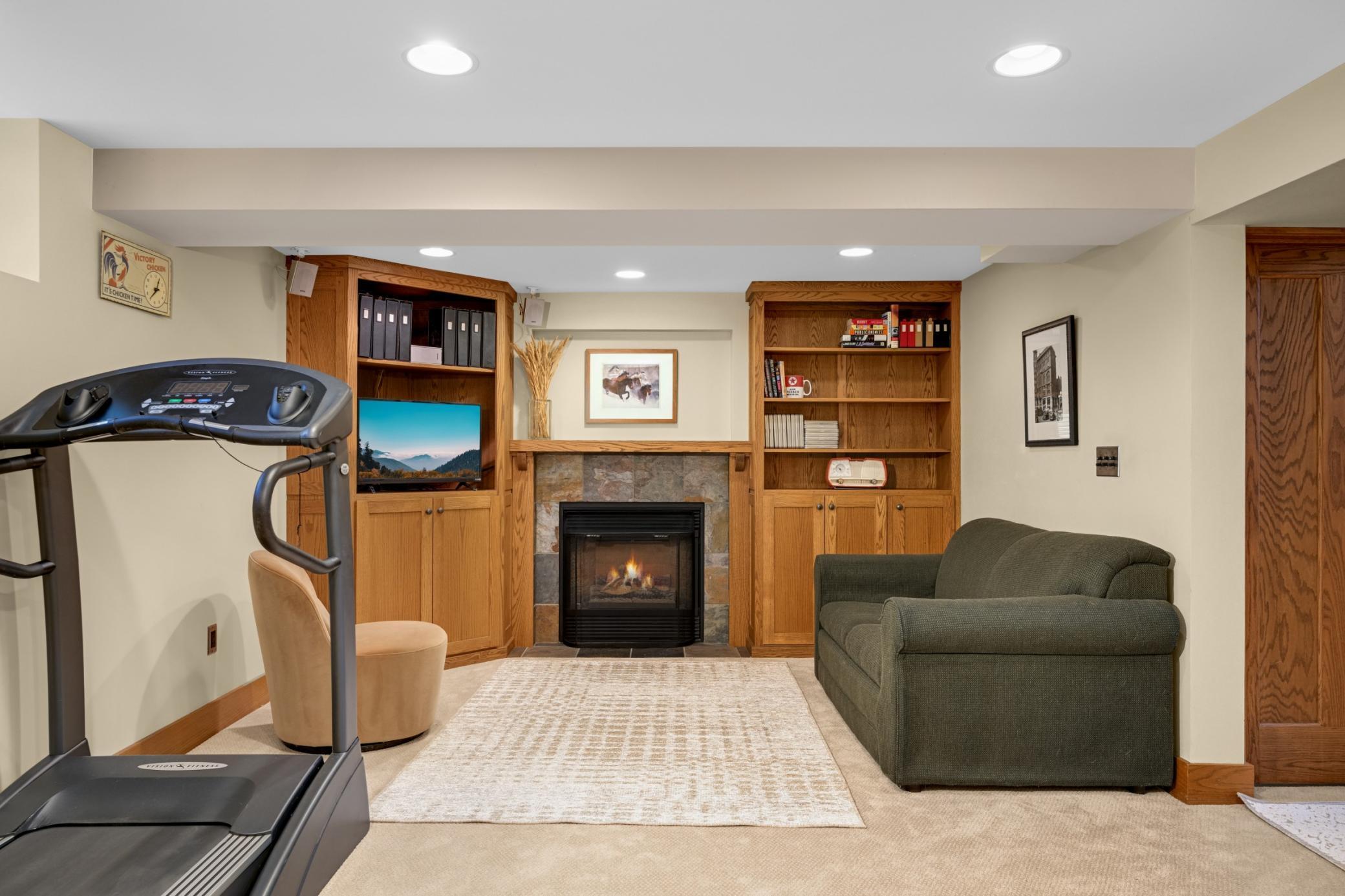 Lower level family room with stone gas fireplace and built-ins.