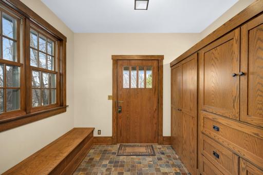 Front foyer with built-ins, bench, and tile.