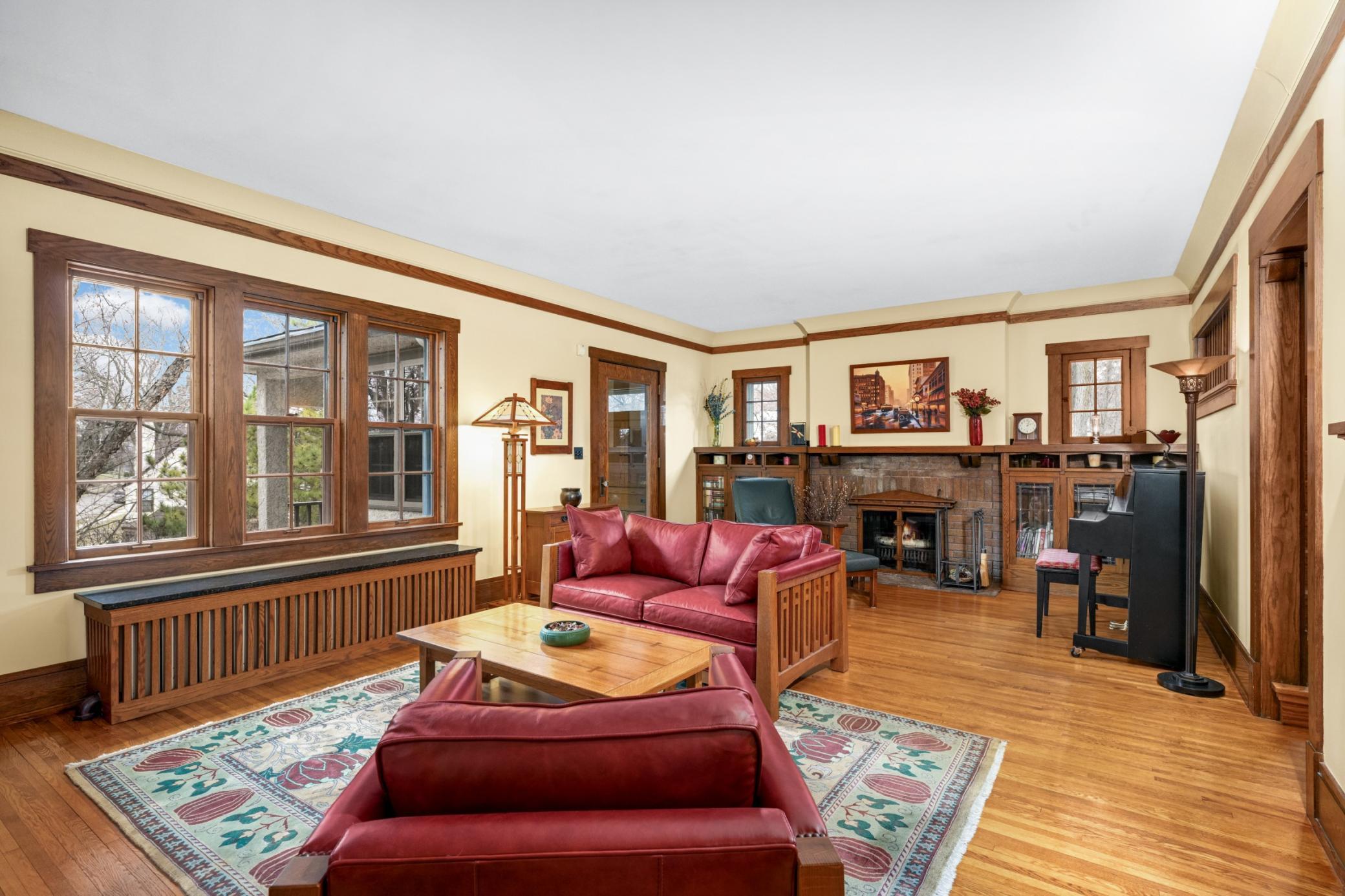 Living room with wood-burning brick fireplace and side transom windows