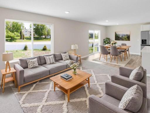 Virtually staged photo of a different home with similar finishes and plan. Great Room and Dining Room.