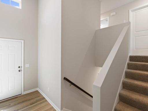Photo of a different home with similar finishes and plan. Foyer view to the staircase.