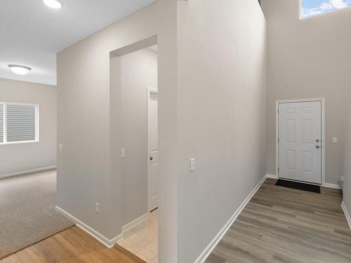 Photo of a different home with similar finishes and plan. Main Floor Hallway View to Foyer and Flex Room.