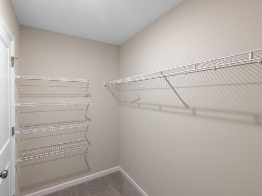 Photo of a different home with similar finishes and plan. Primary Suite Walk-in Closet.