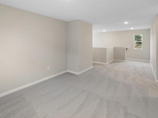Photo of a different home with similar finishes and plan. Upper Floor Versatile Loft view to the staircase and hallway.