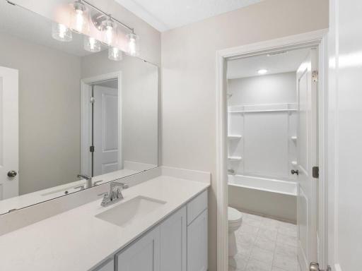 Hall Bathroom. Photo taken of another home with similar plan and finishes. Photos and renderings may not depict actual plan, materials, & finishes may vary. All measurements are approximate.