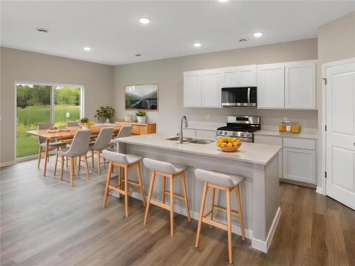 Kitchen and Dining Room. Virtually Staged. Photo taken of another home with similar plan and finishes. Photos and renderings may not depict actual plan, materials, & finishes may vary. All measurements are approximate.