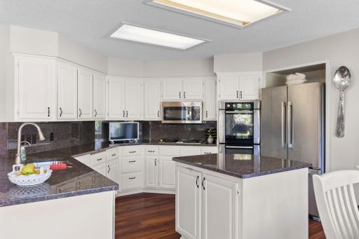 Kitchen features stainless steel appliances including microwave, dishwasher, stove top, double ovens and refrigerator