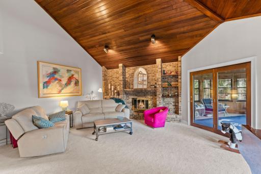 Gas fireplace w/ brick surround and door leads to the 4 Season Porch