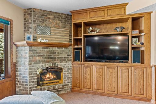 Built-in fireplace in the sun room w/ built-in cabinets for a TV