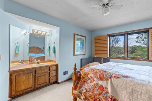 Upper Level Bedroom 2 w/ views of the lake, vanity + sink and ceiling fan