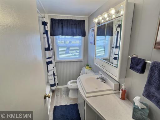 This is another view of bathroom showing vanity and medicine cabinet with mirror.