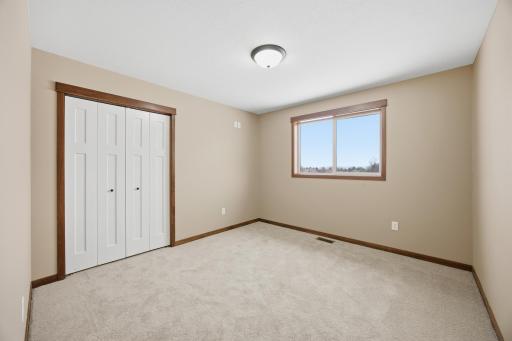 Third bedroom featuring fresh carpet, ample closet space, and peaceful views of the surrounding acreage.