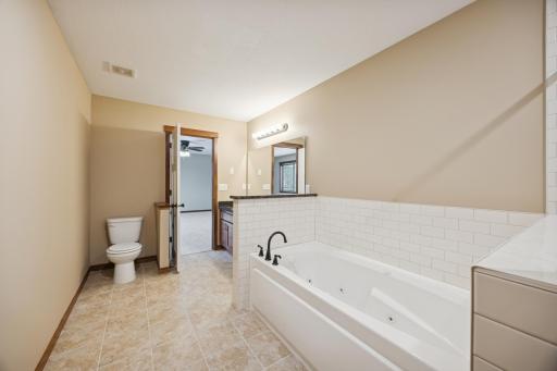 Relaxing primary bath with tiled flooring, soaking tub, and separate shower areaâdesigned for comfort and functionality.
