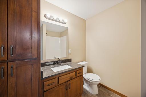3/4 Bathroom featuring a granite-topped vanity with ample storage, updated lighting, and neutral finishes.
