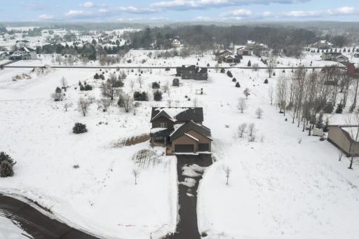 Elevated aerial perspective highlighting the expansive 2.06 acre lot, long driveway, and peaceful neighborhood with room to roam.