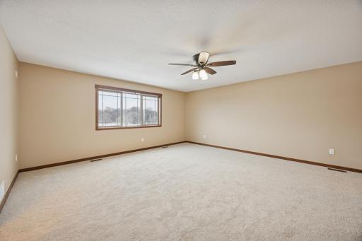 Generously sized primary bedroom with all new carpet, neutral finishes, and large window bringing in natural light.