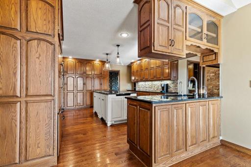 Thoughtfully designed kitchen and entertaining space featuring custom cabinetry, serving station, hardwood floors, and seamless flow throughout the main level.