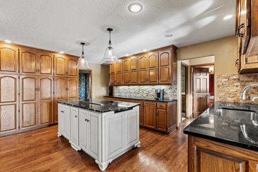 Stunning, beautifully updated kitchen showcasing granite countertops, paneled appliances, and a grand kitchen islandâa chefâs dream with elegant finishes and ample prep space.