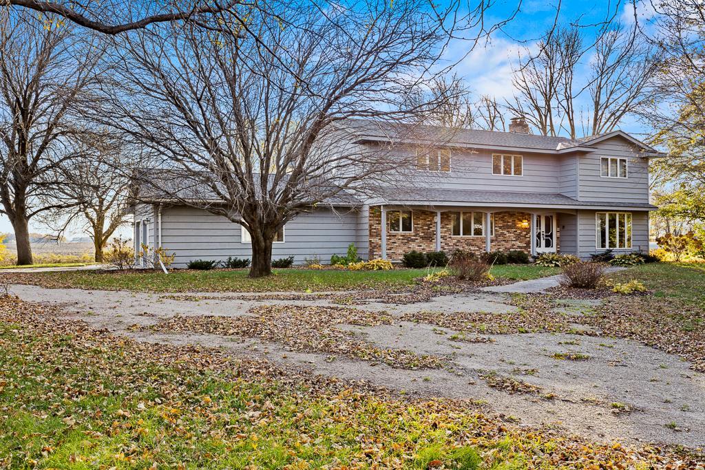 Set on 5 scenic acres, this spacious property offers a private country setting with mature trees, expansive green space, and a welcoming approach.