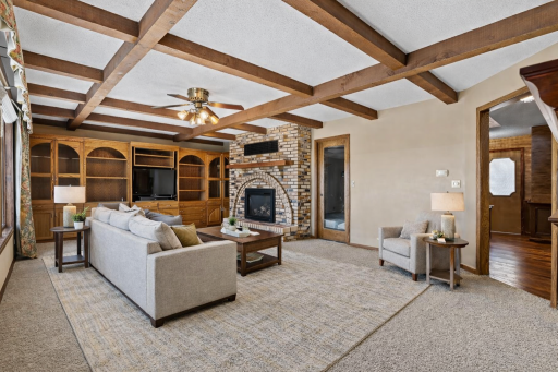Character meets comfort with exposed beams, built-in shelving, and a stunning brick fireplace as the centerpiece of this welcoming space. virtually staged