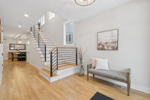Bright foyer with solid white oak floors and modern railing detail.