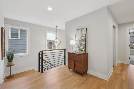 Open stair landing with modern railing and solid white oak flooring.