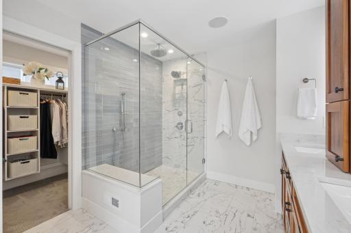 Primary bath walk-in shower with custom tile and multiple shower features.