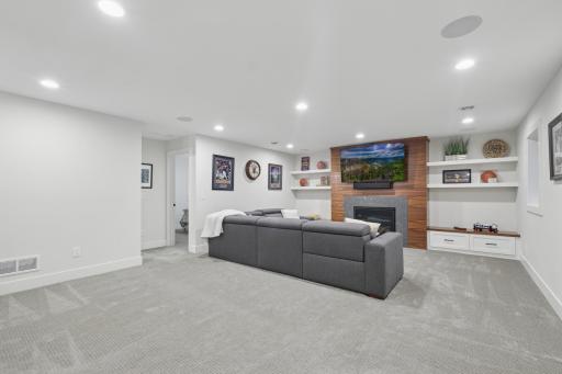 Spacious lower-level family room with recessed lighting and plush carpet.