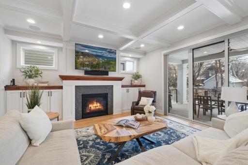 Living room with coffered ceilings leads to the covered deck to extend the entertaining spaces.