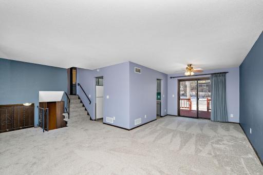 View from living room to dining room, kitchen, and stairs to the upper level.