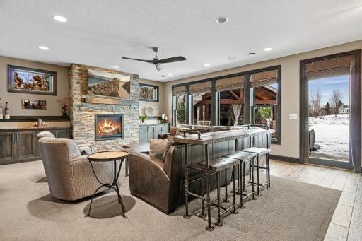 Cozy family room area complete with fireplace and built-ins. Quick access to the walk-up bar, theatre area and outdoor pavilion.