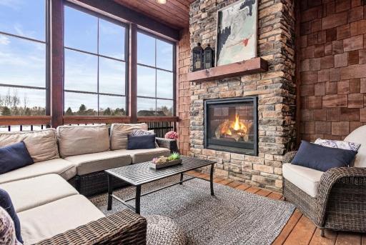 Seasonal porch with vertical-stacking vinyl windows and gas fireplace. Great place to enjoy the game on a summer or fall afternoon!