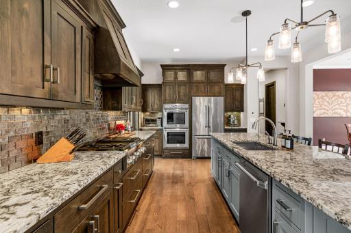 Full-size wine refrigerator, Thermador double ovens and range.