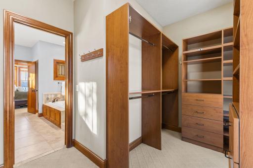 Spacious walk in closet with custom wardrobe system