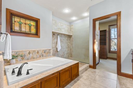 Tiled bathroom with in-floor heat, soaking tub and walk in shower stall