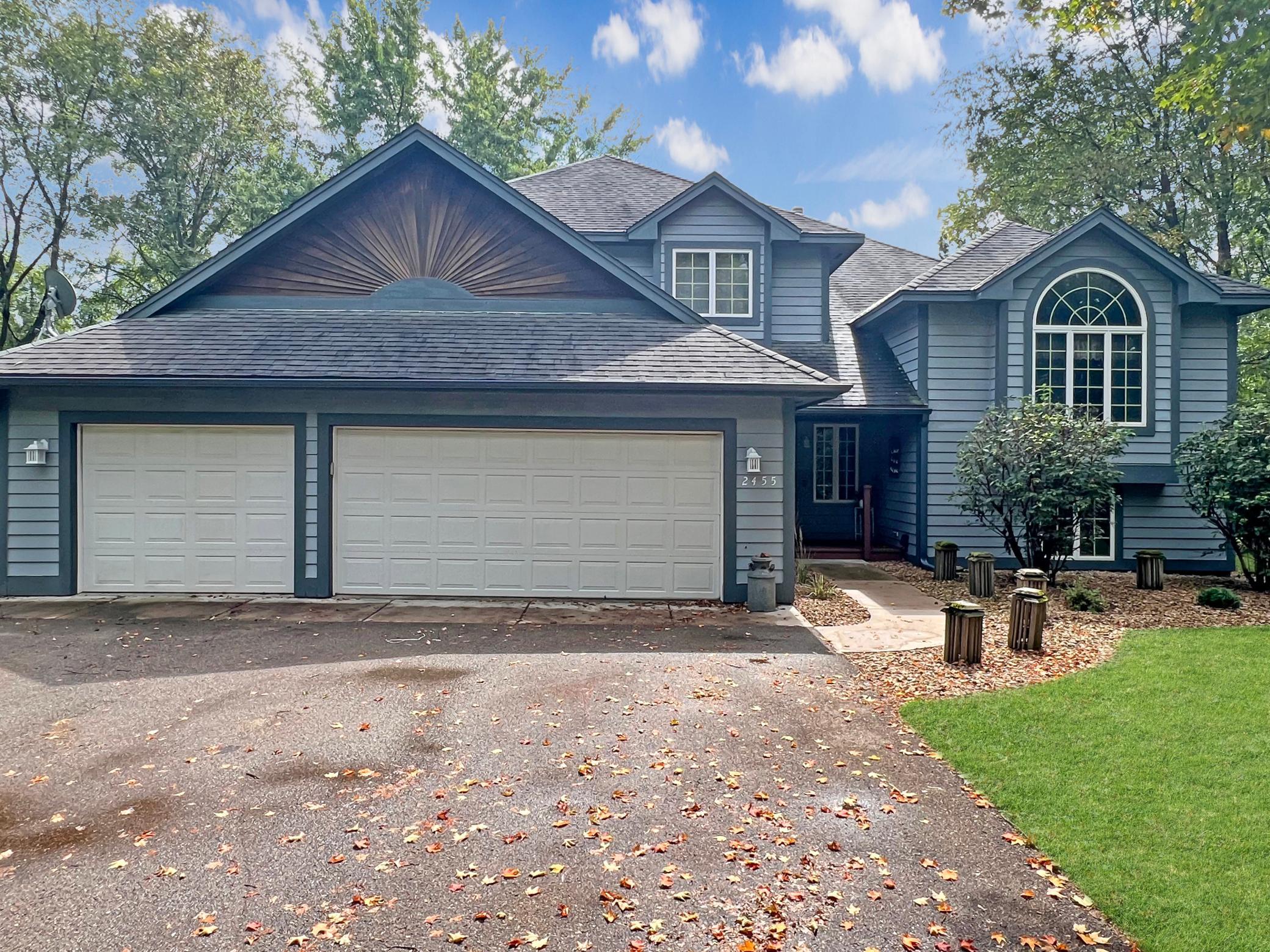 Three car garage plus additional covered space by outbuilding.
